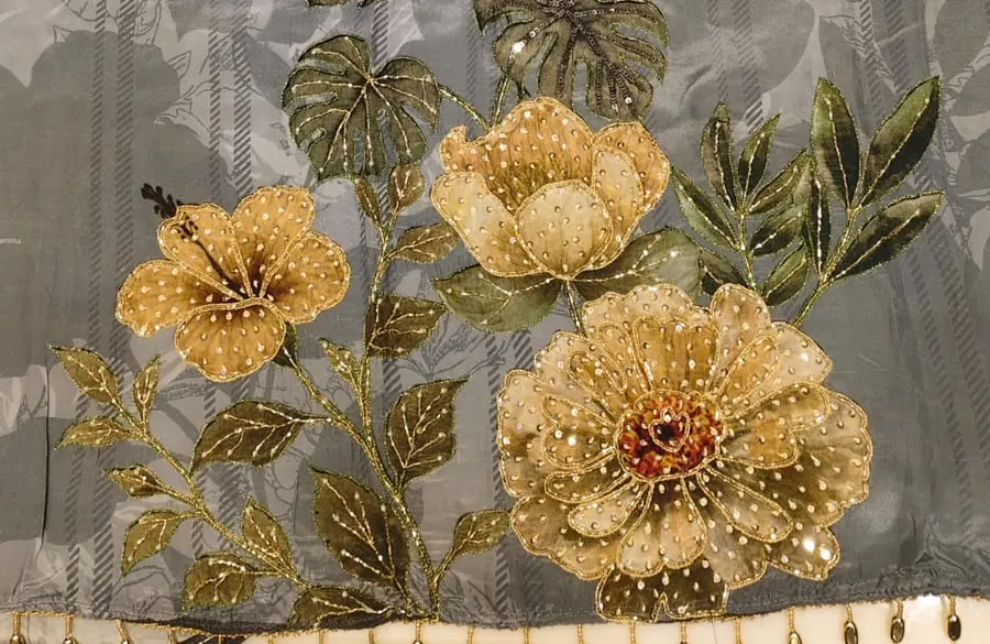 Close-up of raised golden poppy embroidery with sequins